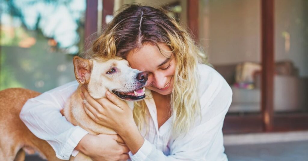 smiling woman hugging her pet