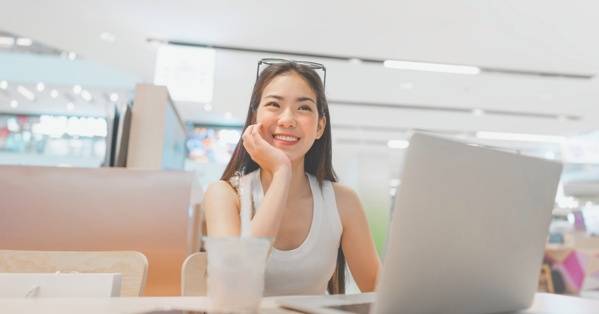 smiling digital nomad woman working with a laptop