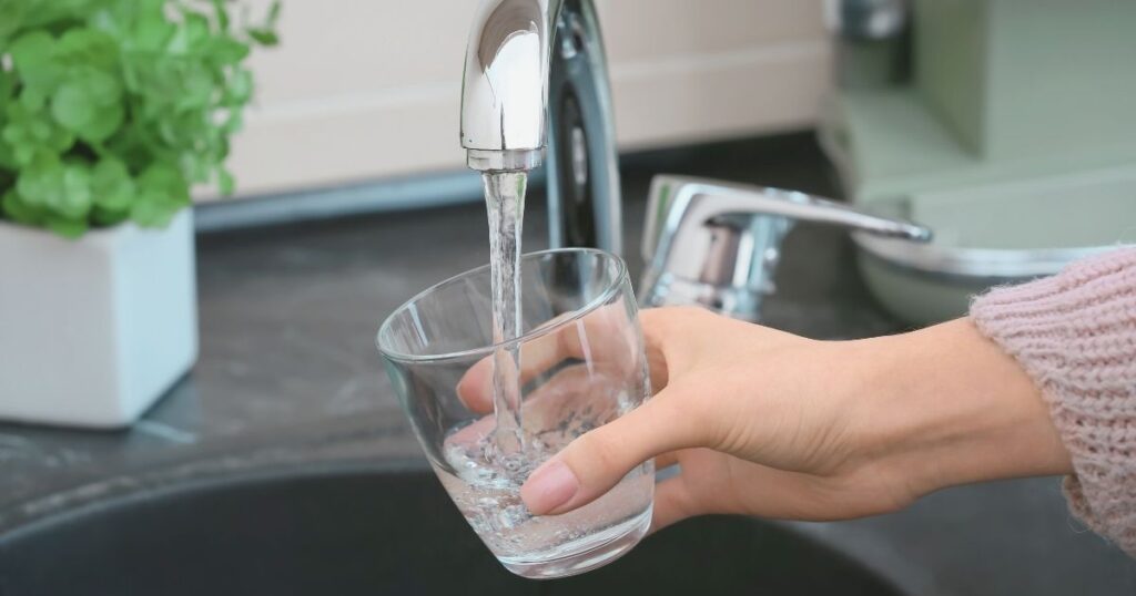 mujer tomando agua del grifo en Noruega