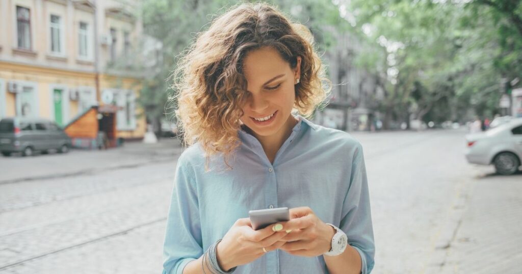 mujer sonriente usando aplicacion de Wifi gratis