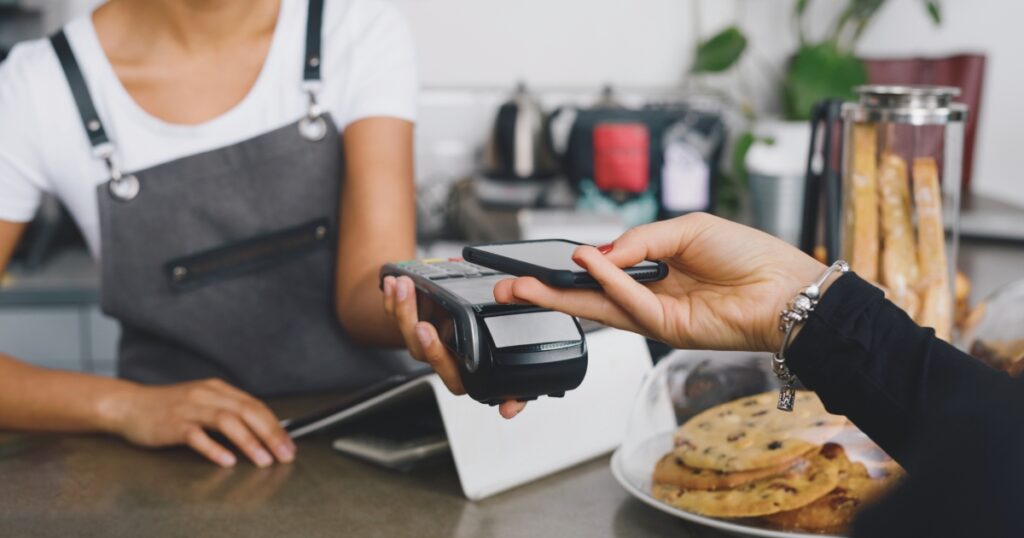 mujer haciendo el pago con su celular en España