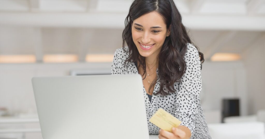 mujer sonriendo al comprar en una de las tiendas online más populares de España