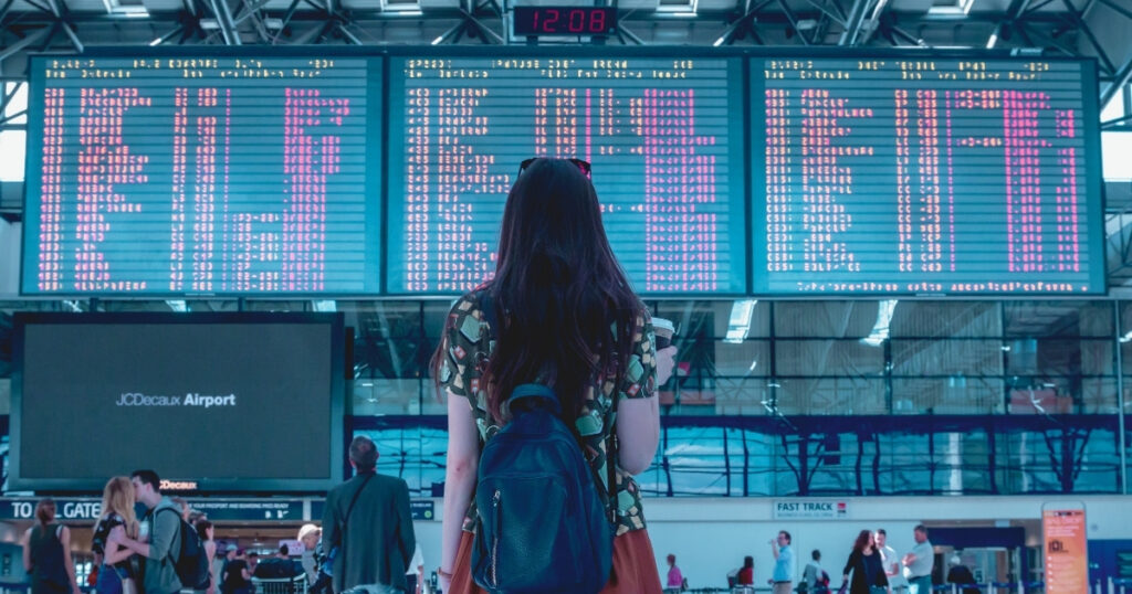 mujer joven en el aeropuerto antes de viajar barato con millas