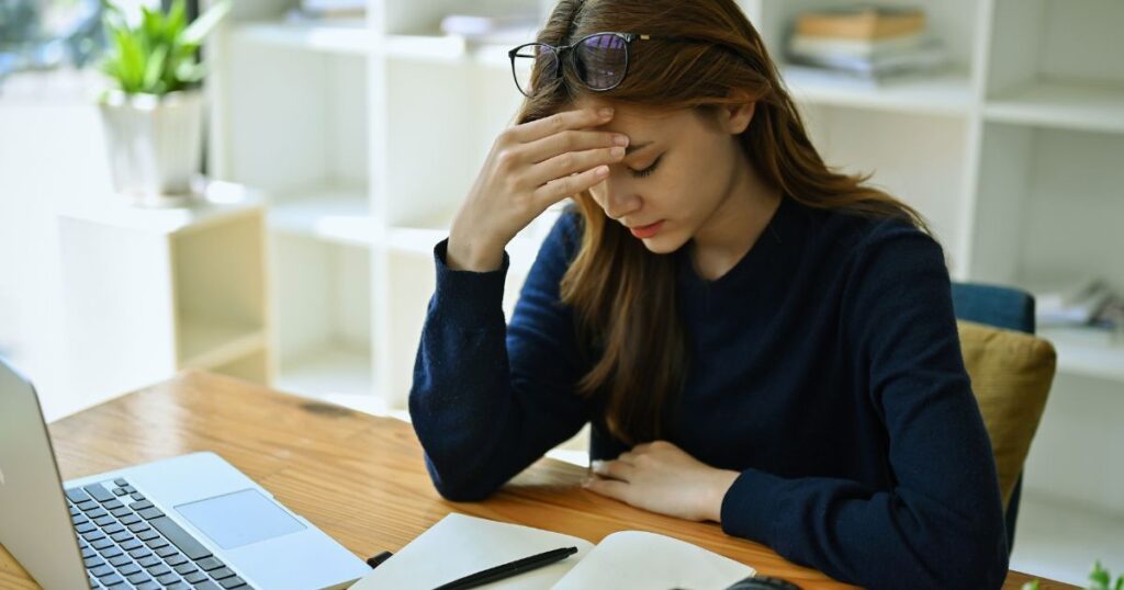mujer preocupada leyendo sobre las razones por la cual un país sea uno de los peores para vivir