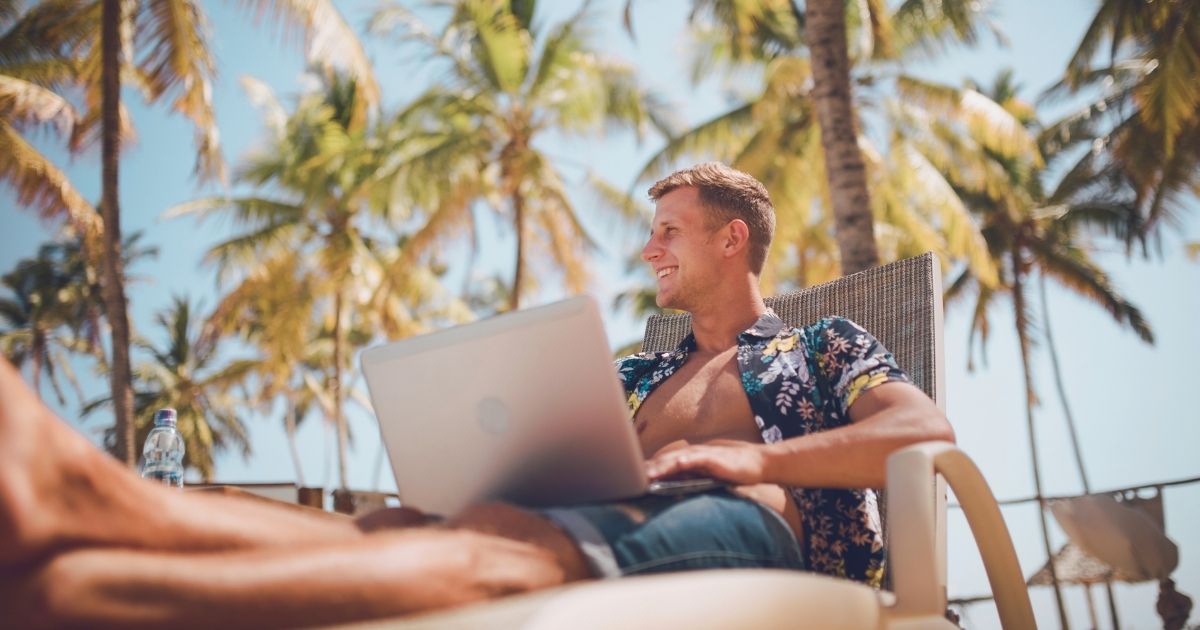 young man working remotely from the beach in Indonesia