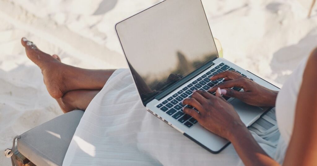 mujer trabajando en su laptop en la playa en Brasil