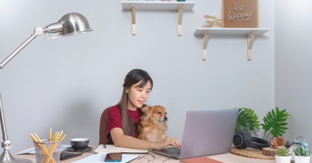 woman working remotely with her dog