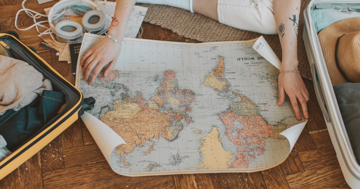 person using a map for creating a travel itinerary