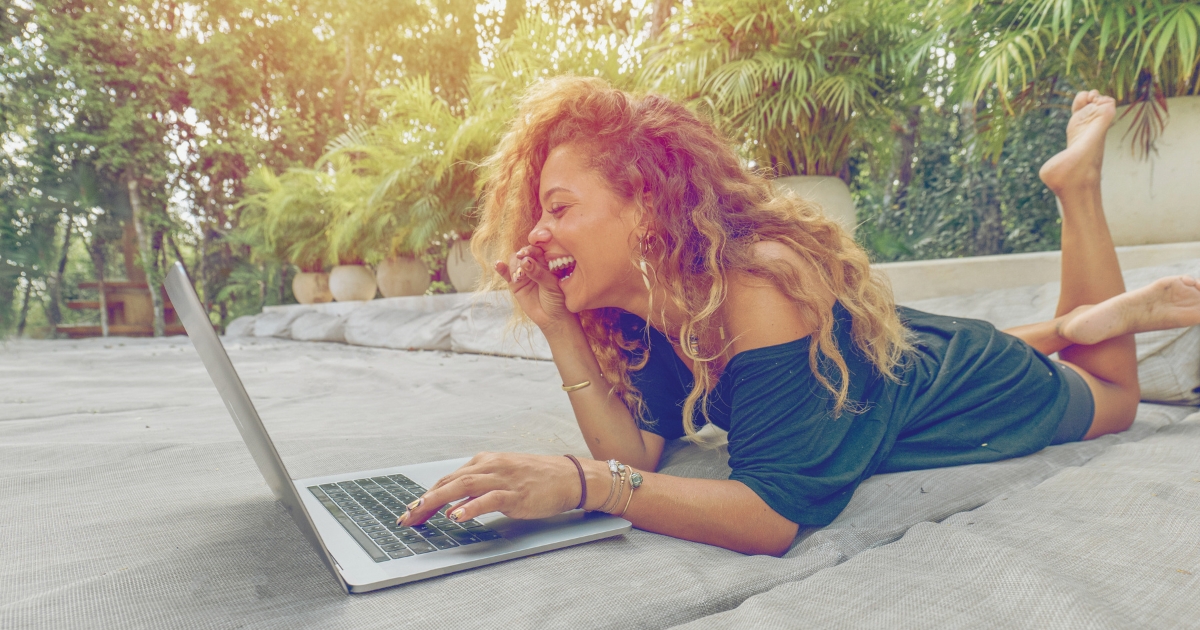 woman smiling while using her smartphone while living in Europe as a digital nomad