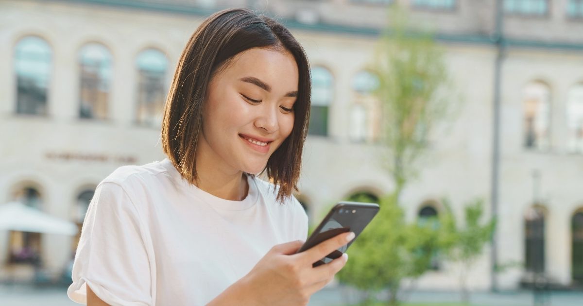 mujer sonriente navegando en internet con la mejor esim de Europa