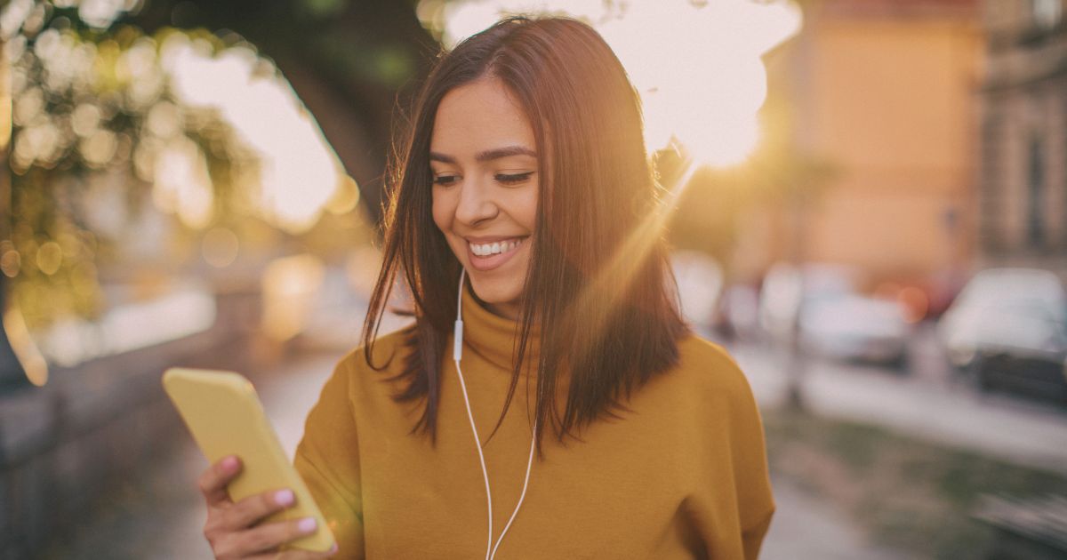 mujer joven navegando en su celular con una esim online
