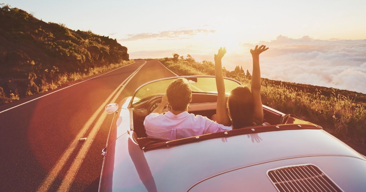 traveler couple in a road trip in the UK with a rental car