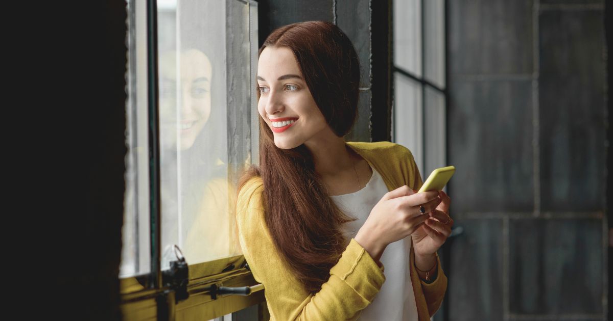 mujer feliz usando una esim en su celular