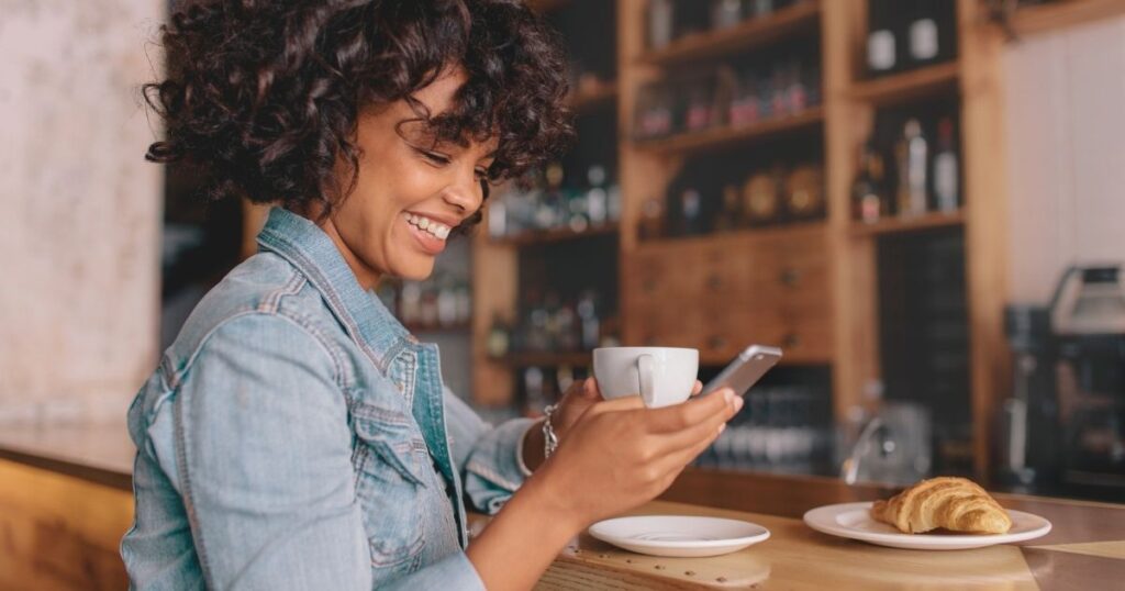 mujer sonriente usando internet en su celular 