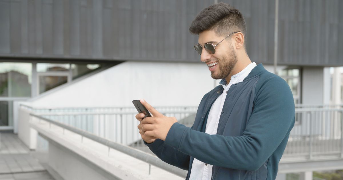 hombre feliz navegando en internet en su celular