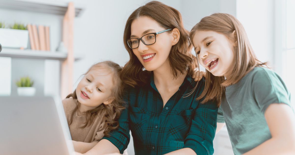 mujere nomada digital con sus hijas trabajando en remoto