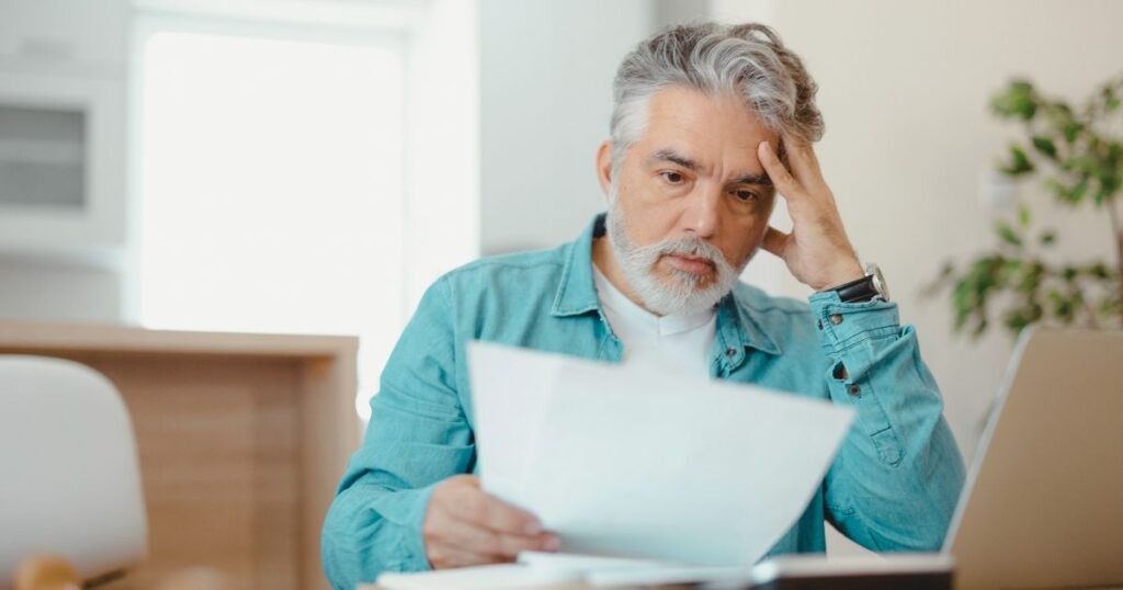 man paying penalties for not paying taxes in Spain