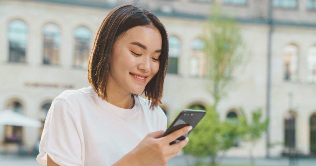 mujer sonriente usando esim en su celular