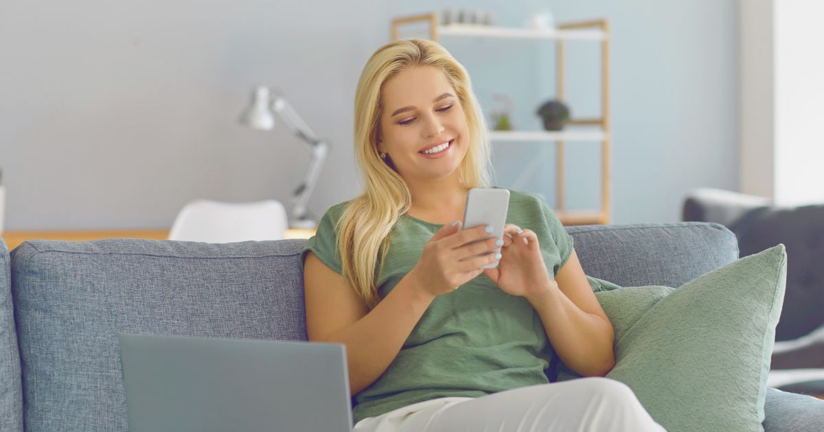 mujer feliz navegando en internet con una esim en su celular