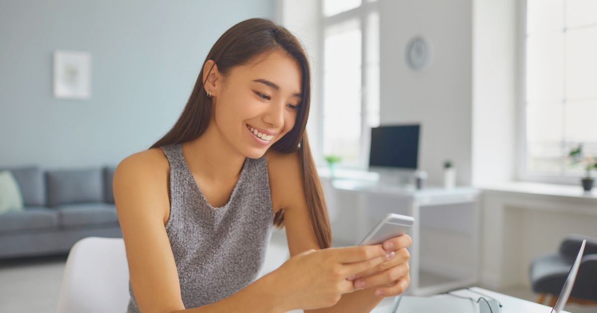 mujer sonriente utilizando esim en su celular