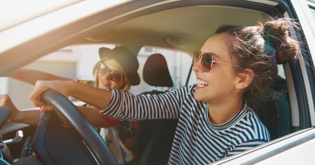 mujer feliz conduciendo coche alquilado en Costa Rica