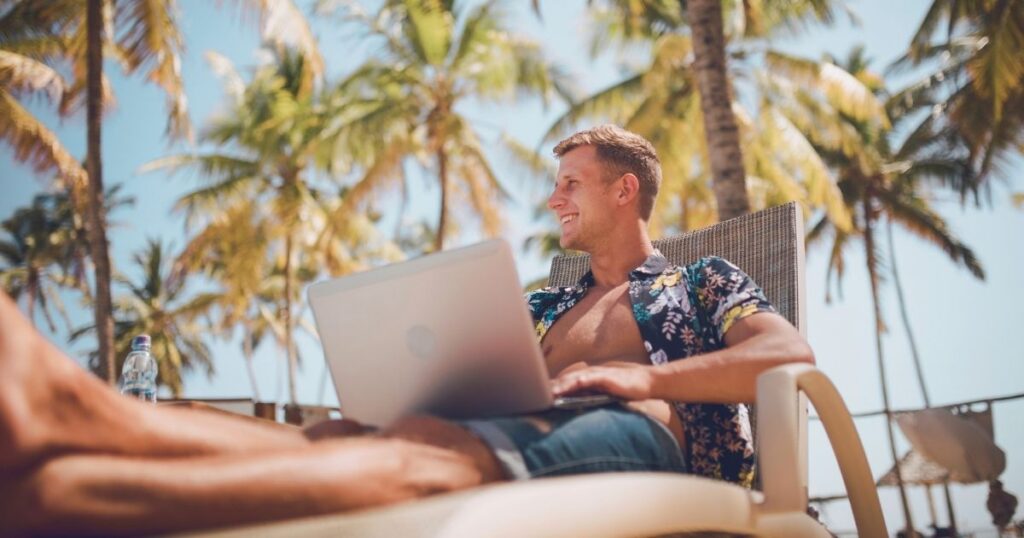 smiling man working from the beach in Bali