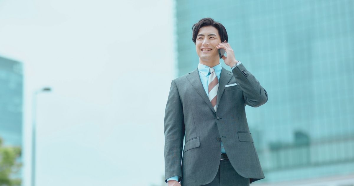 hombre sonriente navegando en internet en su celular con una esim en Japon