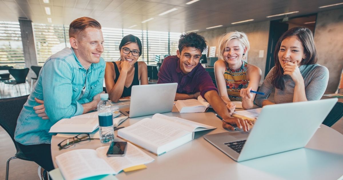 estudiantes extranjeros usando internet en sus laptops