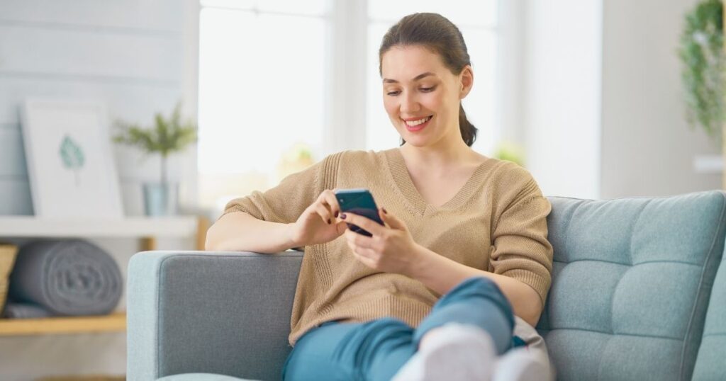 smiling woman navigating on internet in Barcelona