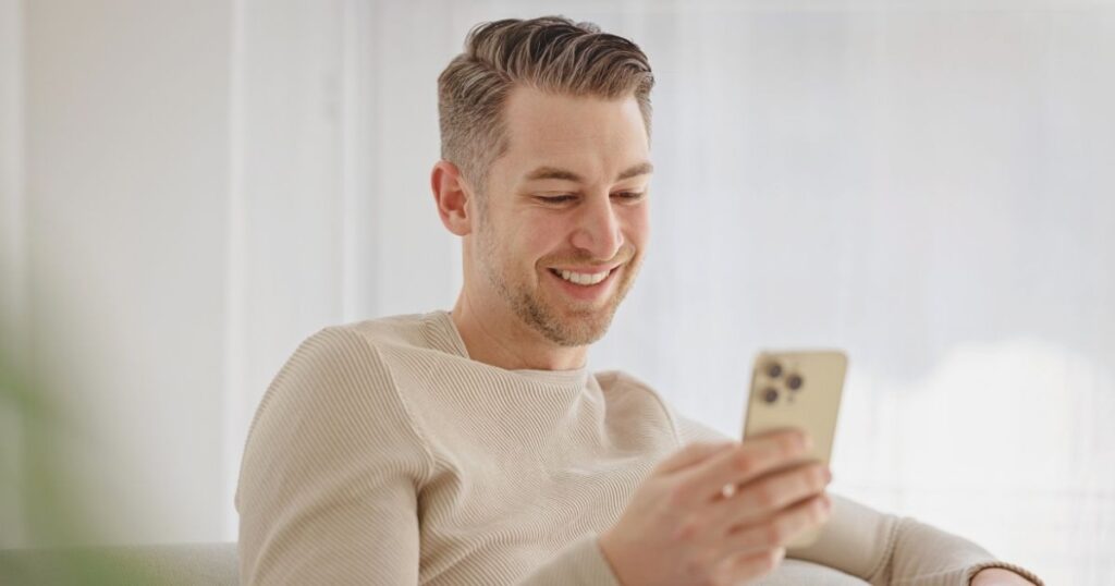 hombre sonriente navegando en internet con esim de Holafly