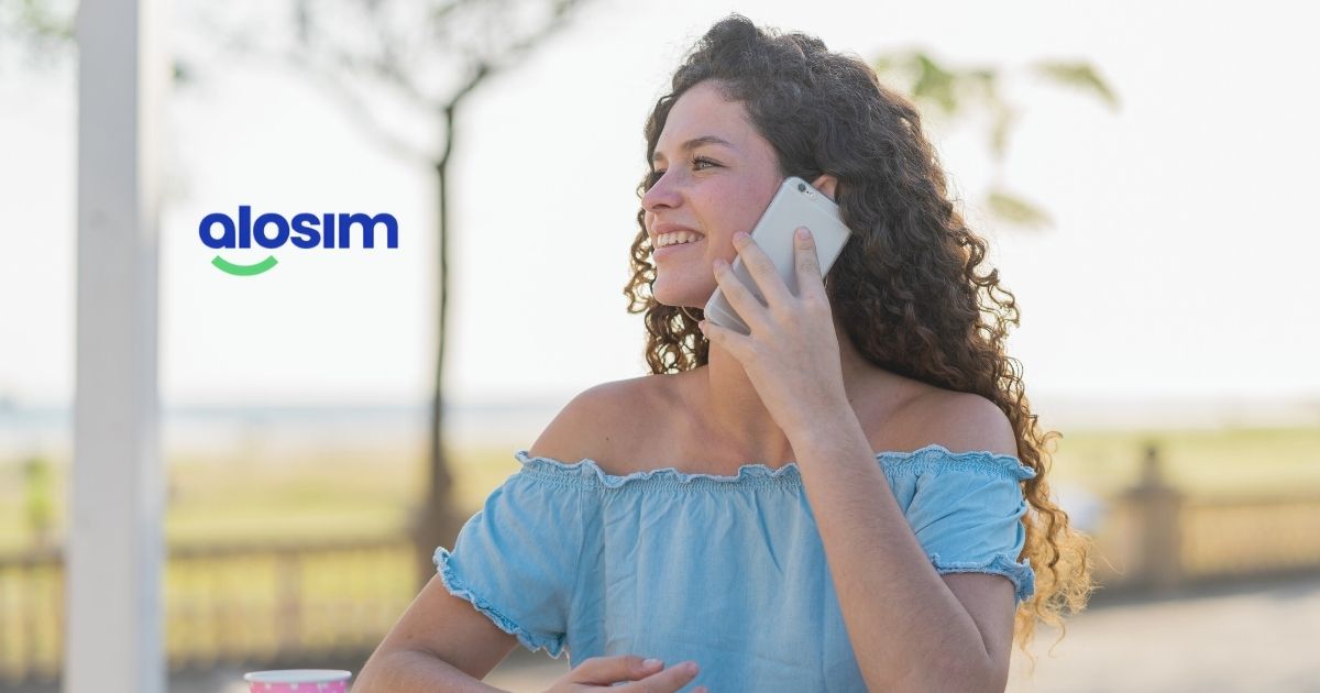 mujer sonriente usando Alosim esim en su celular