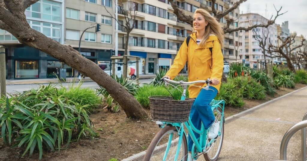 mujer feliz andando de bicicleta y disfrutando de un turismo sostenible