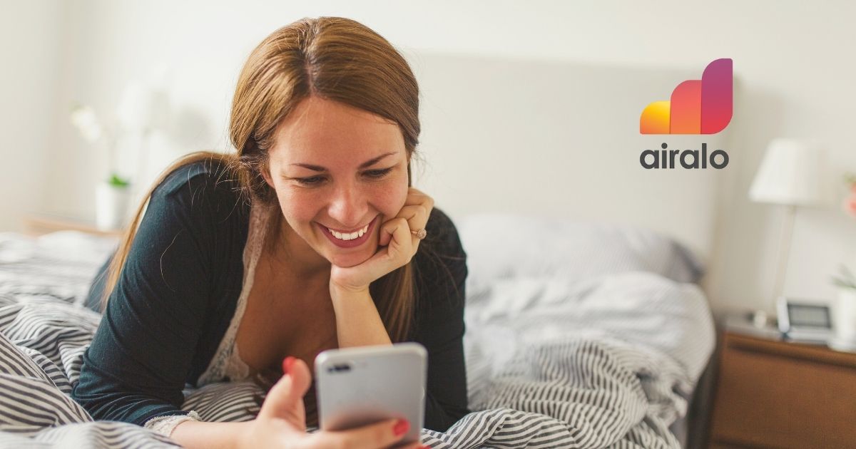 smiling woman using Airalo esim