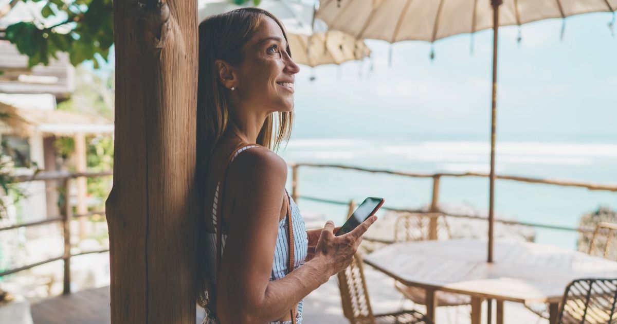 smiling woman using esim in her cellphone