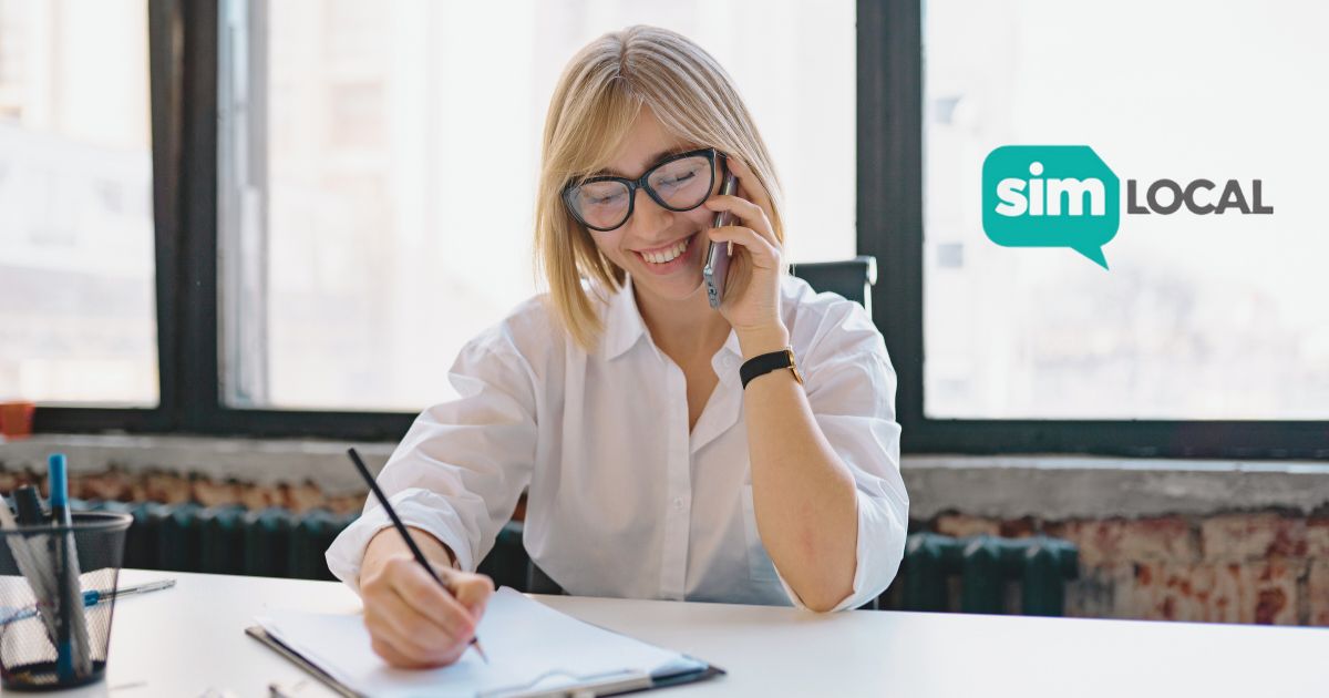 mujer sonriente usando Simlocal en su celular