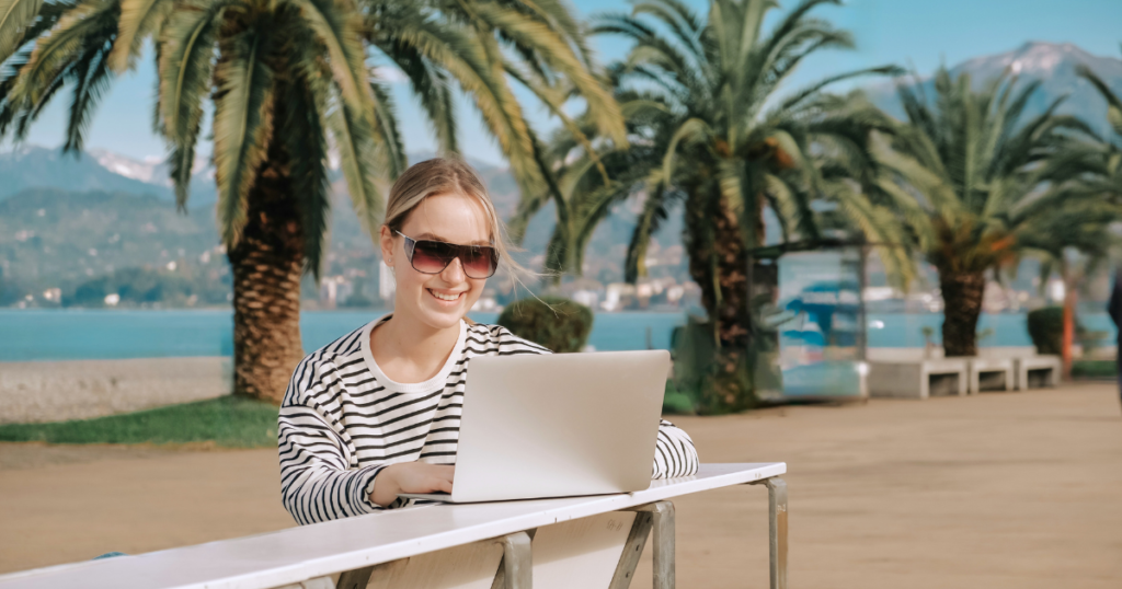 mujer nomada digital trabajando en la playa